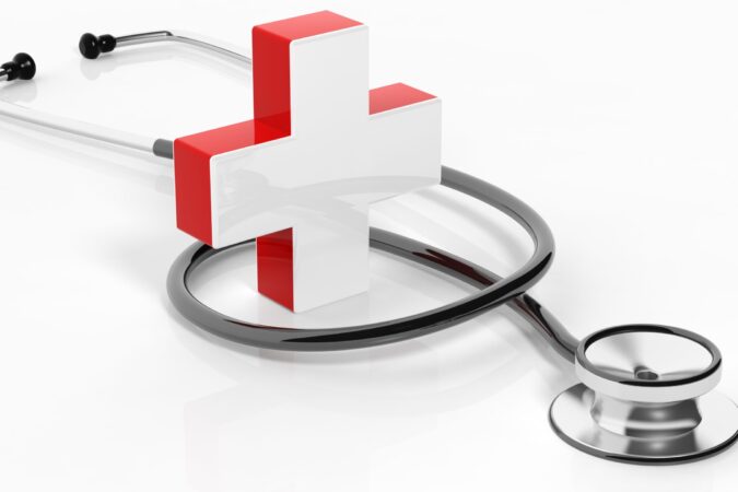 Medical cross with stethoscope isolated on white